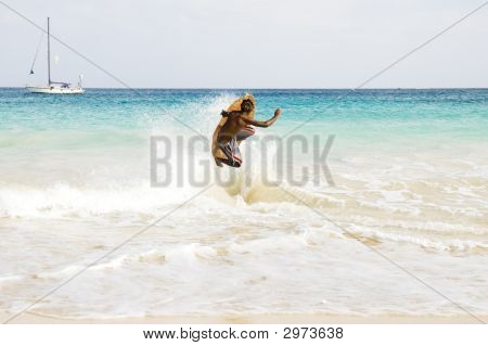 Skimboarder skákání vlnu.
