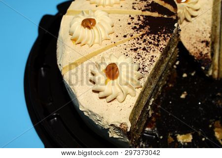 On A Blue Background In A Brown Substrate Half Cake Caramel Biscuit With Cream