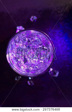 Glass Of Pure Water With Ice Cubes. View From Above. Abstract Dynamic Backdrop For Your Design