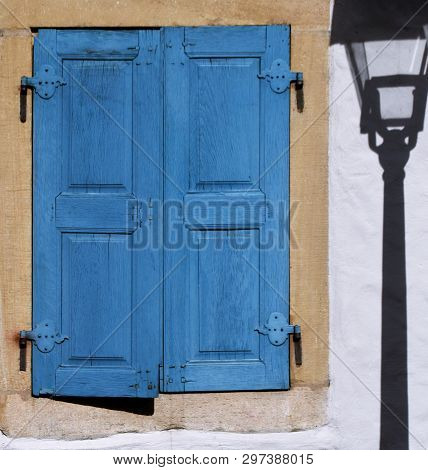 Close Up Of A Street Lamp With Its Shadow On The House Wall