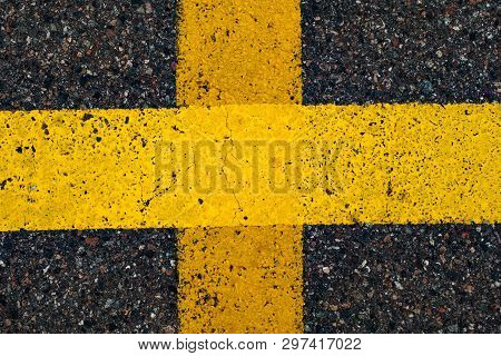 Road Marking Line With Yellow Paint On Asphalt. In The Shape Of A Cross. Marking The Motorway. Close