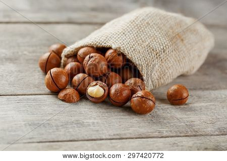 Macadamia Nut On A Wooden Table In A Bag, Closeup, Top View