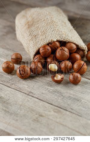 Macadamia Nut On A Wooden Table In A Bag, Closeup, Top View