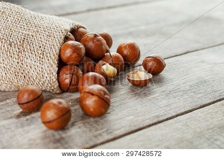 Macadamia Nut On A Wooden Table In A Bag, Closeup, Top View
