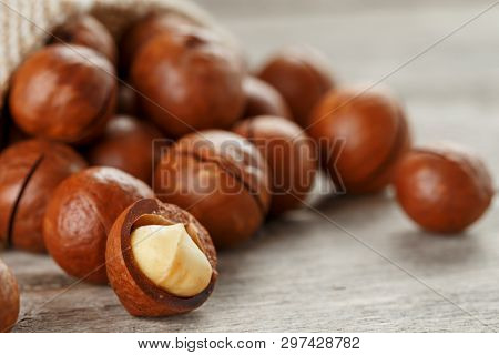 Macadamia Nut On A Wooden Table In A Bag, Closeup, Top View