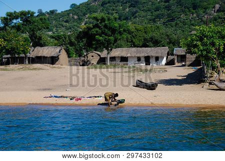 Lake Malawi, Malawi, 4/3/07 A Single Woman Washing Clothes At The Edge Of The Water, Lake Malawi, Ma