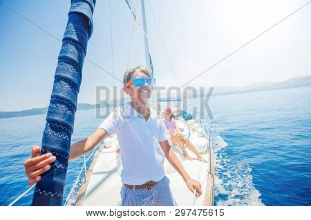 Little Boy With His Mother Having Fun On Board Of Yacht On Summer Cruise. Travel Adventure, Yachting