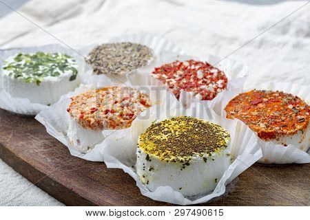 Assortment Of French Fresh White Soft Goat Cheeses With Different Tastes Topping Made With Herbs, Pa