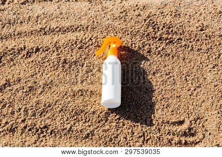 Suntan Lotion White Bottle On Sand With Copy Space. Sunblock Spf Cream On The Sea Beach In Summer Va