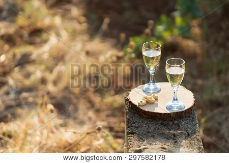 Two Glasses Of Fresh White Wine On A Wooden Board A Traditional Italian Snack - Taralli On A Bright 