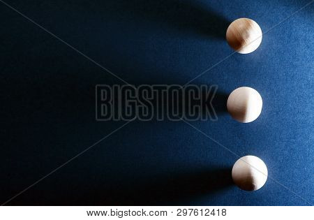Abstract Composition With Three Small Wooden Balls On Dark Blue Background