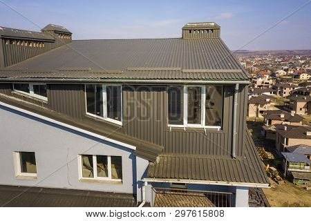 Aerial View Of Attic Annex Room Exterior With Plastic Windows, Roof And Walls Covered With Brown Met