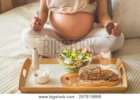 Pregnancy And Healthy Organic Nutrition. Pregnant Woman Enjoying Fresh Vegetable Salad In Bed, Free 