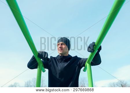 Photo of athlete pulling up on green horizontal bar