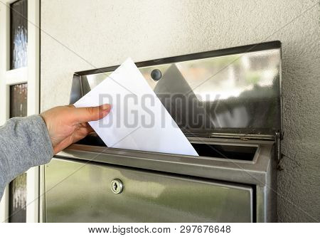 A Man Hand Putting Mail In Mailbox