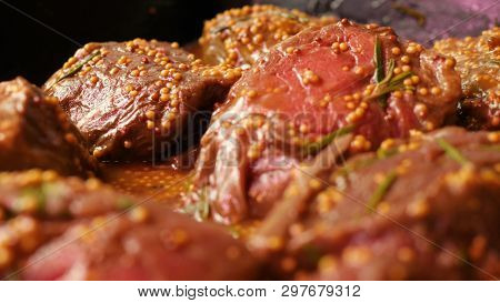 Pieces Tenderloin Of Raw Beef Meat Marinated With Mustard Seeds And Rosemary Are Lying In Black Tray