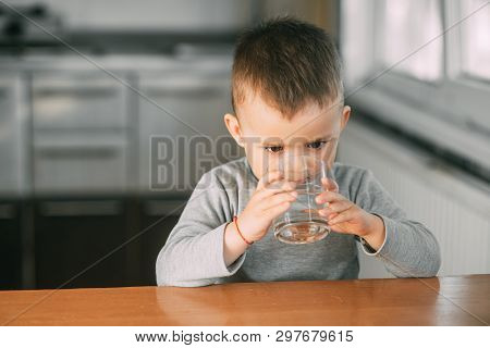 Portrait Of A Boy Drinking A Glass Of Water,happy In The Kitchen