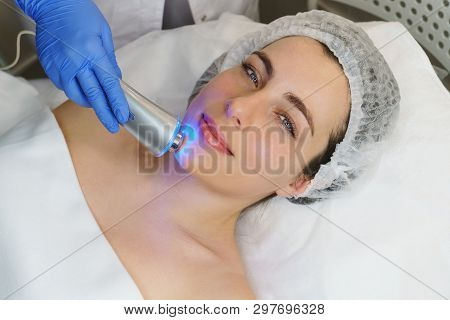 Hardware Cosmetology. Ultrasound Chromotherapy. Beautician Carries Out Procedure For Tightening Skin