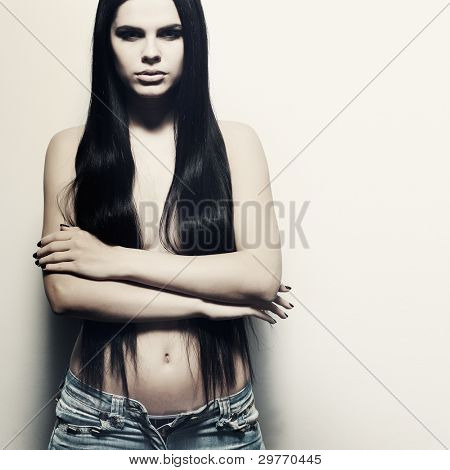 Fotografie sexuální krasavicí v džínách, stojící nedaleko walll je v módní styl, kouzlo