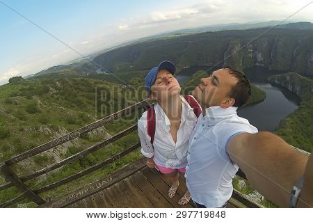Young Couple, Man And Woman Making Selfie Photo On The View Point. Top Of The Hill And Panorama Of C