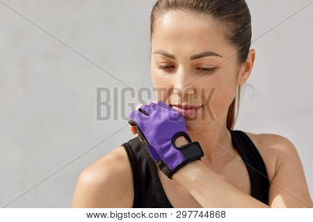 Close Up Portrait Of Young Beautiful Brunette Female Dressed Sportwear And Fitness Gloves, Looks Tho