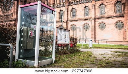 Freiburg Im Breisgau, Germany - December 31, 2017: Deutsche Telekom Phone Booth In Front Of A Church