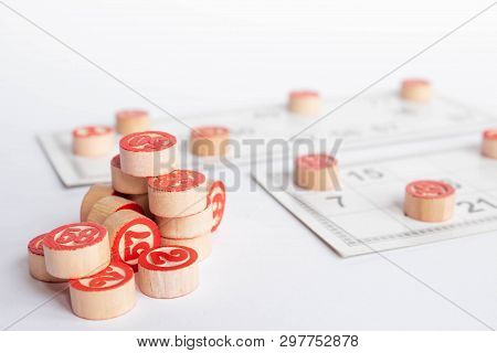 Bingo Or Lotto Game. Wooden Kegs Of Lotto On Cards. Cards And Chips For Playing Bingo On A White Tab