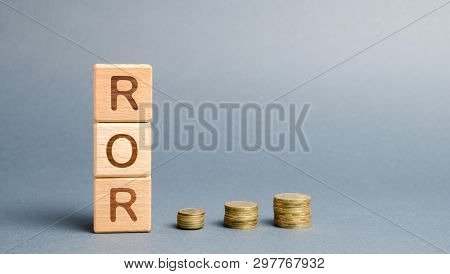 Wooden Blocks With The Word Ror And Coins. High Level Of Business Profitability. Return On Investmen