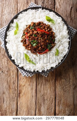 Thai Basil Chicken With Spicy Chili Pepper And Soy Sauce With Rice Garnish Close-up On A Plate. Vert