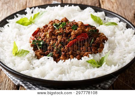 Delicious Basil Chicken With Chili Pepper And Soy Sauce With Rice Garnish Close-up On A Plate. Horiz