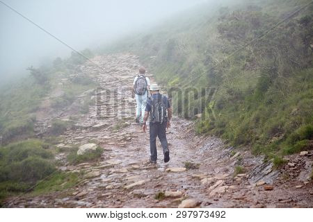 Couple Of Hikers Walking In Mountains. Hiking Trail In The Pyrenees. La Rhune Mountain, France
