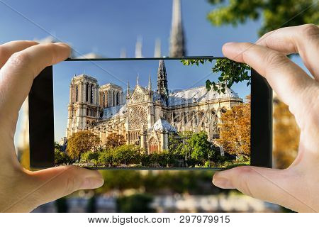 Tourist Taking Photo Of Notre Dame De Paris In Summer, France. It Is A Famous Landmark Of Paris. Pic