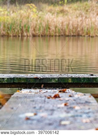 Wet Fushing Pond Mole. Wooden Pier On The Pond And Autumn Leaves. Silent Autumn Nature.