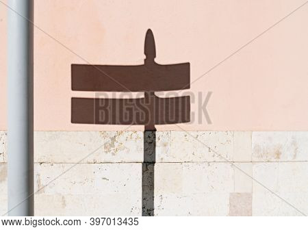 Shadow Of A Street Sign On The Concerete Wall Painted Pink And Stone Decoration