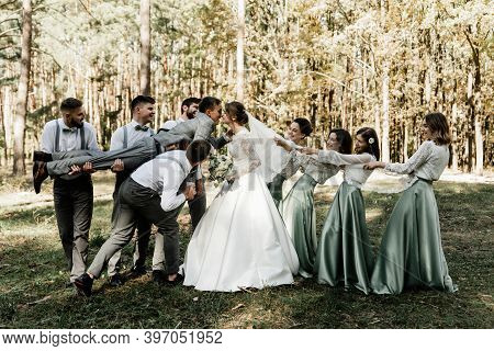 Cheerful Friends Of The Groom And Bridesmaids Holding The Newlyweds In Their Arms, Wedding Mood, Gro
