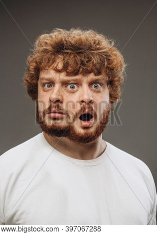 Shocked, Amazed. Young Man With Dual Emotions Combination On Face Isolated On Dark Background, Emoti