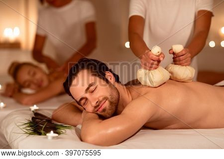 Spouses Enjoying Herbal Back Massage And Aromatherapy Lying And Relaxing In Spa Center Indoors. Mass
