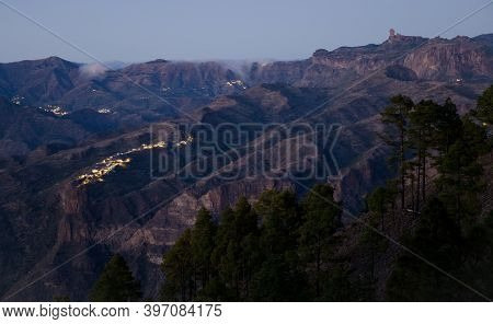 Roque Nublo To The Right And Village Of El Toscon In The Foreground At Sunset. The Nublo Rural Park.