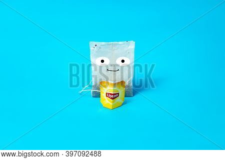 The Tea Bag Looks At The Lipton Label. On A Blue Background