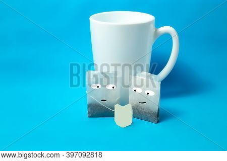 Two Tea Bags Look At The Label. On A Blue Background