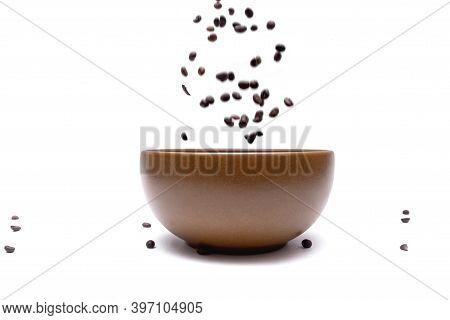 Flying Coffee Beans Into A Brown Bowl On A White Background, Close-up. Blurred. Selective Focus. Dyn