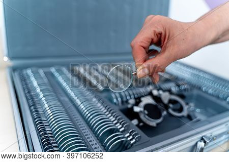 Corrective Glasses With Replaceable Lenses. Ophthalmology Clinic Concept. Hand Holds Lense.
