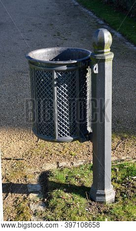 Cast Iron Trash Can In Park On Lawn With Path Around Detail Gray Color A Bit Historicizing  Metal Po