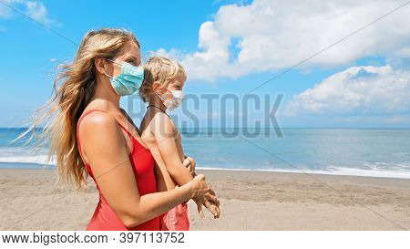 Mother Put Medical Mask On Child On Sea Beach. New Rules To Wear Cloth Face Covering At Public Place