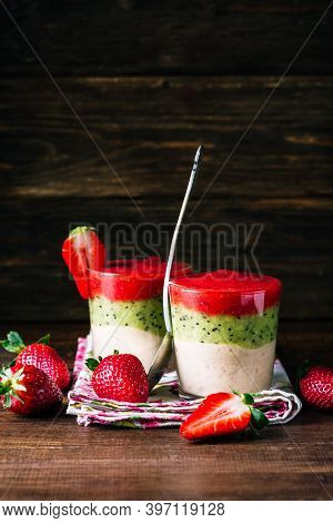 Banana Kiwi And Strawberry Smoothie And Strawberries On A Black Wooden Background