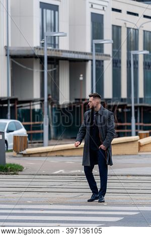 Crosswalk. Young Man In Elegant Coat Looking Attentively Crossing The Street.