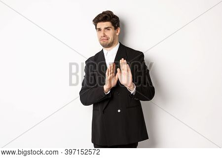 Image Of Stylish Handsome Man In Black Suit, Cringe From Something Embarrassing, Declining Offer And