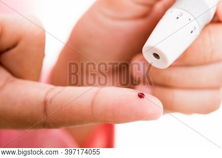 Closeup Woman Measuring Glucose Level Using A Hand Test Lancelet On The Finger She Monitors High Blo