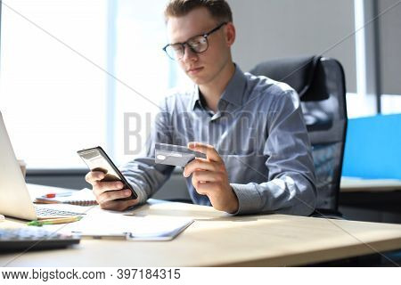 Modern Man Using Credit Card And Mobile Phone For Online Payment. Mobile Shopping Concept.