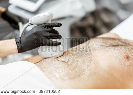 Man During An Ultrasound Liposuction Procedure At Luxury Spa Salon. Doctor Working On Abdomen Area, 
